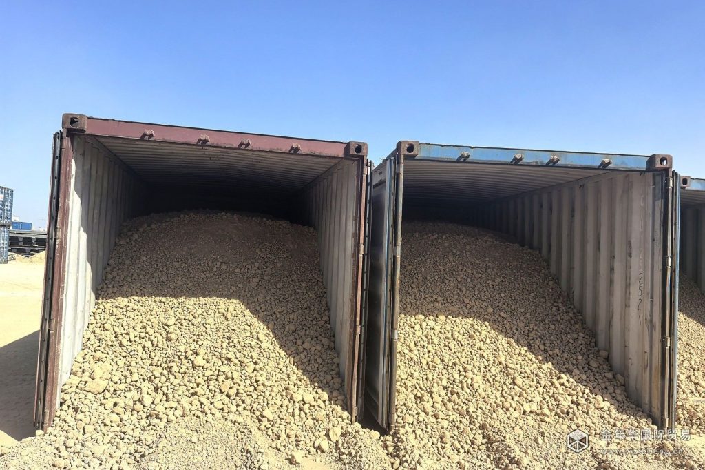 Two open-top containers loaded with phosphate rock at a port